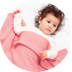 bébé sous couverture rose